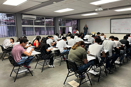 Estudiantes secundarios preparándose para evaluación diagnóstica con lápices y borradores, mostrando un ambiente escolar organizado.