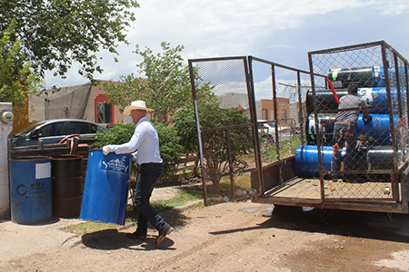 Ammón Dayer Lebaron Tracy entregando tambos de basura a los ciudadanos de Galeana para mantener la comunidad limpia.