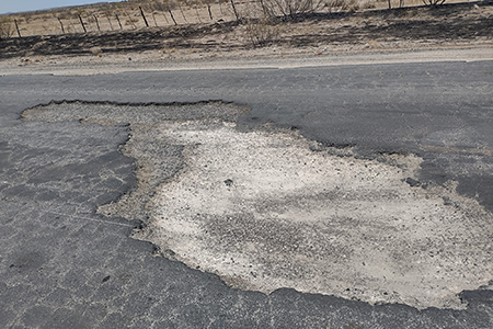 Imagen de una carretera en mal estado en Chihuahua, destacando los daños y baches que afectan a los automovilistas. La SCOP informa que casi el 50% de las carreteras federales requieren rehabilitación.