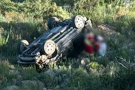 Camioneta volteada en la carretera Janos-Agua Prieta tras accidente, con paramédicos rescatando a los heridos.