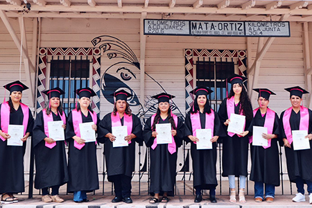 Graduadas del curso de costura en Juan Mata Ortiz, orgullosas con sus togas y birretes confeccionados por ellas mismas.