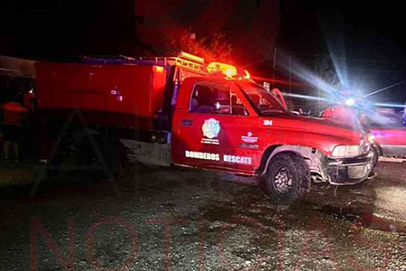 Camión de bomberos estacionado en la calle mientras los bomberos trabajan para apagar el incendio en el ejido Benito Juárez.