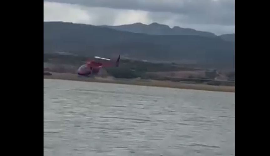 Helicóptero que combatía incendios cayó en la presa Chihuahua, movilizando cuerpos de emergencia. Las labores de rescate continúan en busca de un tripulante.