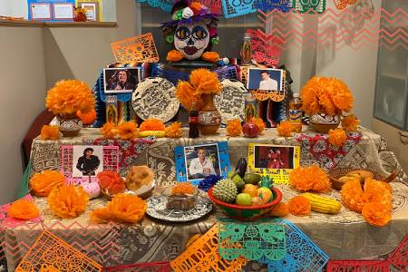 Ofrenda de Día de Muertos en México, con flores de cempasúchil, pan de muerto y velas que simbolizan el regreso de los seres queridos.