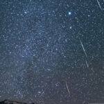 Cielo estrellado iluminado por la lluvia de estrellas Táuridas en México, con meteoros visibles sobre el horizonte en una noche despejada de noviembre.